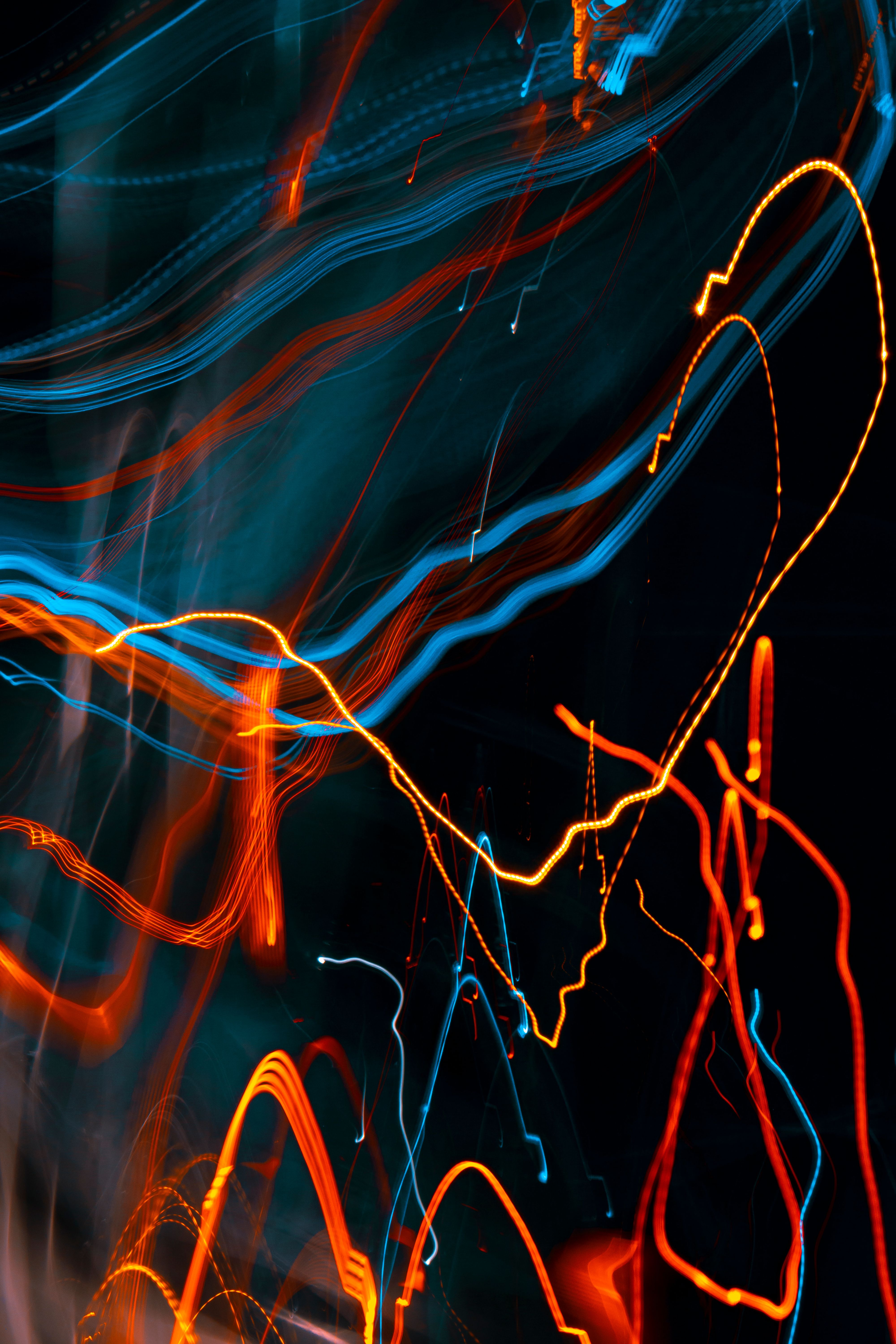 Orange and blue light streaks arcing across a black background.