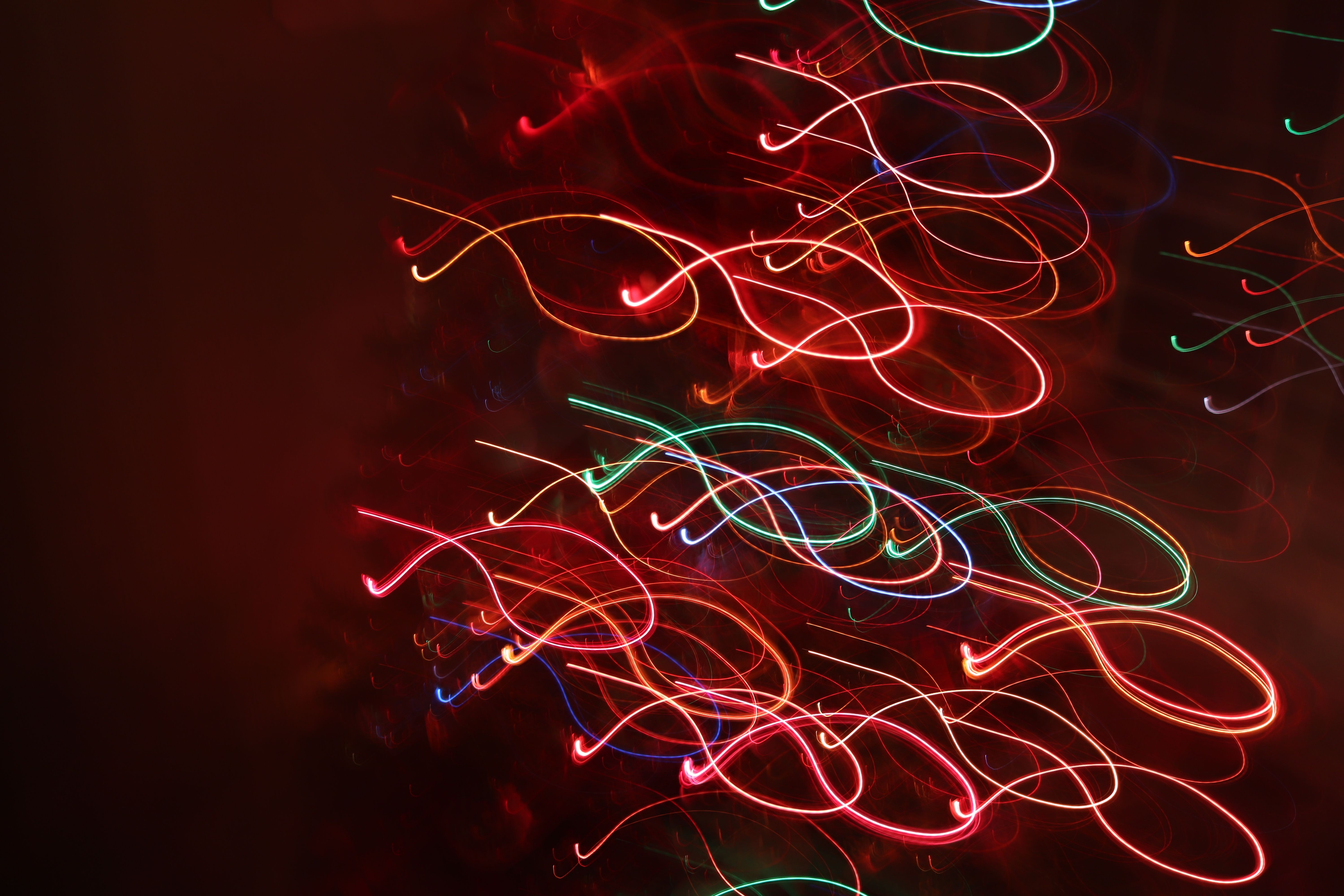Long-exposure ribbons of coloured light forming a layered shape.